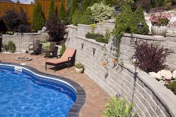Scapes Inc Landscaping OKC shows a photo of a retaining wall next to a pool.
